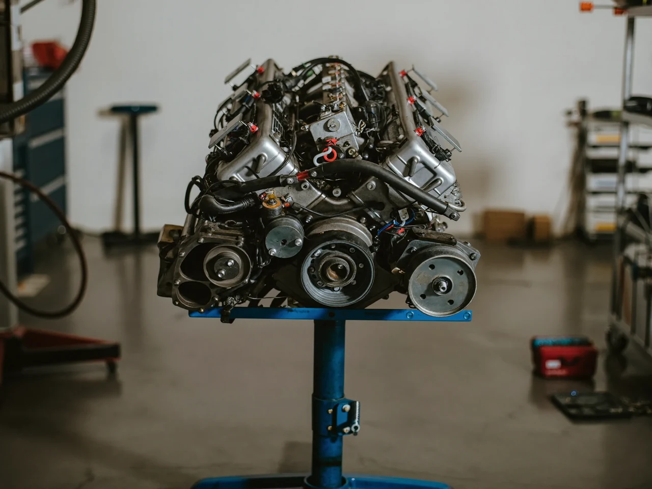 Ilustrație: motor reconstruit, așezat pe un stand metalic într-un atelier curat